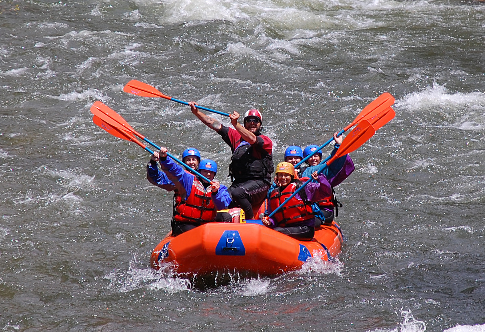 Rafters holding up their oars in triumph.